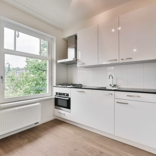 51079680 a kitchen with white cabinets and a window