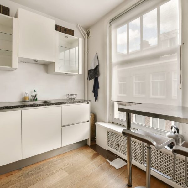 55824634 a kitchen with white cabinets and a window